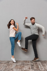 Wall Mural - Full length portrait of a happy young couple celebrating