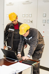 Wall Mural - field service engineers inspect relay protection system with laptop computer