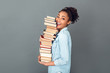 Young african woman isolated on grey wall studio casual daily lifestyle holding books profile