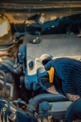 checking the oil level in a car engine