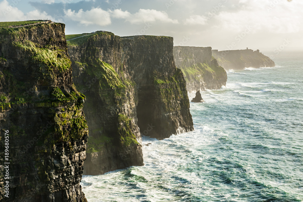 The Cliffs of Moher, Irelands Most Visited Natural Tourist Attraction, are sea cliffs located at the southwestern edge of the Burren region in County Clare, Ireland. - obrazy, fototapety, plakaty 