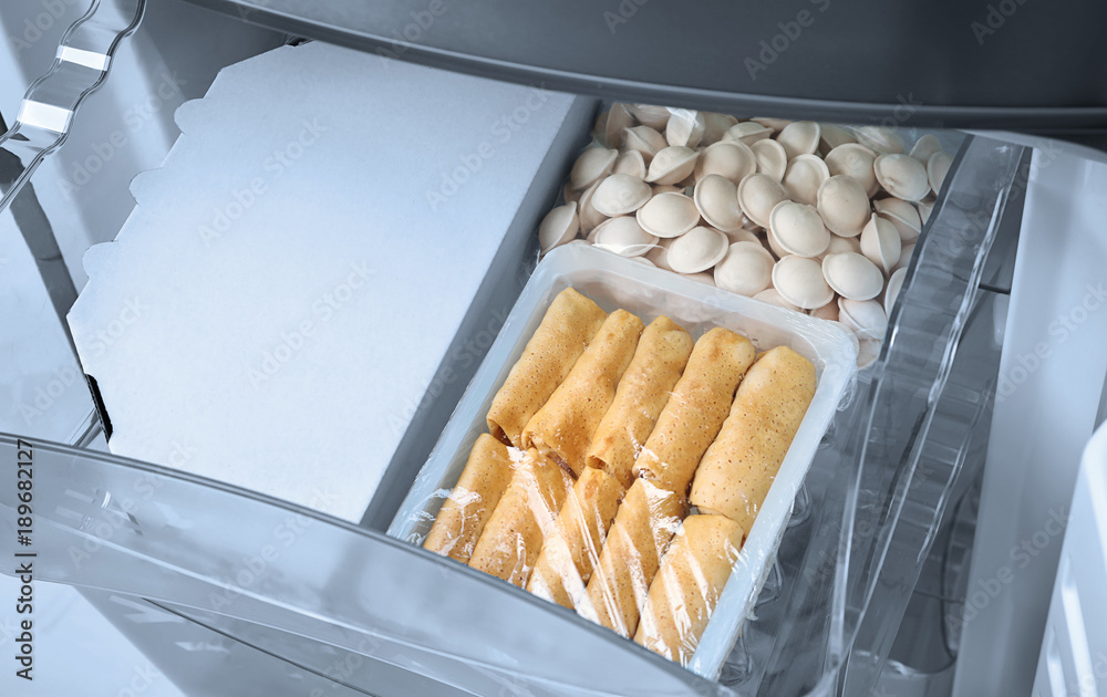 Frozen processed food in refrigerator icebox, closeup