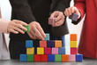 Group of people with colorful cubes, closeup. Unity concept