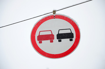 Road sign. Overtaking is prohibited. The sign prohibits overtaking all vehicles on the road section. A red and black car is depicted in a framed red circle