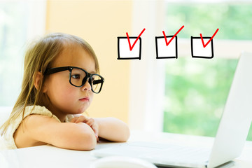 Wall Mural - Checklist with little girl using her laptop