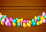 Fototapeta  - Easter frame with shiny colorful happy eggs spread over wooden background