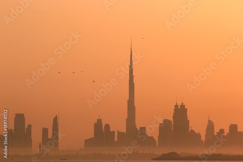 Fotomural DUBAI SKYLINE UNDER SUNRISE, TWO LANDMARKS, BURJ AL ARAB AND BURJ KHALIFA, THE T