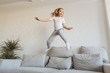 © LIGHTFIELD STUDIOS - smiling kid jumping on sofa and listening music with headphones