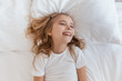 © LIGHTFIELD STUDIOS - top view of smiling adorable child lying on bed