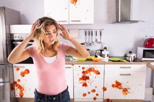 Cuadros en Lienzo Worried Young Woman Standing In Dirty Kitchen