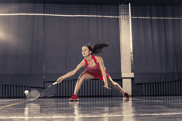 Wall Mural - Young woman playing badminton at gym