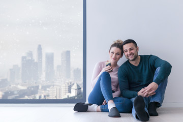 Wall Mural - young couple sitting on the floor near window at home