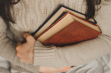 Young girl holds two books in hands