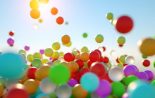 Colorful Bouncing Balls Outdoors Against Blue Sunny Sky