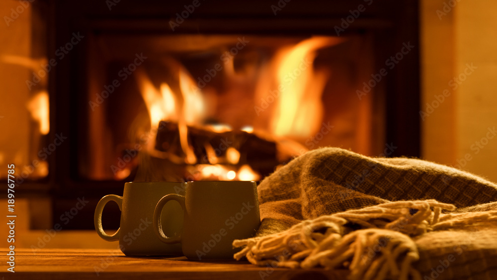 Steam from a cups with a hot cocoa on the fireplace background.   - obrazy, fototapety, plakaty 