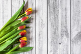 Fototapeta Tulipany - Bukiet kolorowych tulipanów na drewnianym stole z miejscem na tekst