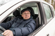 © YuSafa - An elderly man is sitting at the wheel of a car.