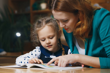 Wall Mural - Mother helping kid after school. preschooler doing homework with help of tutor. home teaching concept.