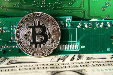 Wall Mural - silver bitcoin coin with dollars and computer motherboard, cryptocurrency mining concept