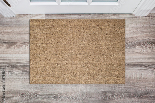 Blank tan colored coir doormat before the white door in the hall. Mat on wooden floor, product Mockup © maddyz