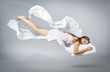 © akvafoto2012 - Sleeping girl. Flying in a dream. White linen flying through the air.