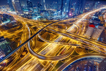 Aerial View Of Big Highway Interchange With Traffic In Dubai, UAE, At Night. Scenic Cityscape. Colorful Transportation, Communications And Driving Background.