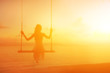 © Glebstock - Woman on swing silhouette with brightly sunset colors on background