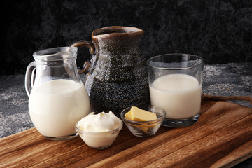 milk products - tasty healthy dairy products on a table sour cream in a bowl, cream and milk jar