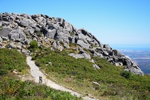 Mountain path leading to large rocks with across the Monchique mountains and countryside, Algarve, Portugal.