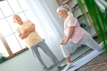 Wall Mural - Senior couple doing yoga together at home health care stretching leg