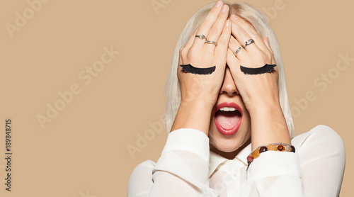 Fotografía Funny young woman with eyelashes painted on the hand