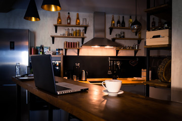 Kitchen with bar counter. Home atmosphere, work in the evening after a hard day with cup of coffee. Home office.  