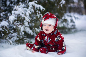 Wall Mural - Little cute smiling baby boy, sitting outdoors in the snow