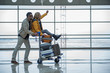© Yakobchuk Olena - Joyful start of journey. Profile of happy young couple is having fun in terminal lounge. Man is pushing airport trolley with suitcases and his cheerful girlfriend who is sitting on it. Copy space