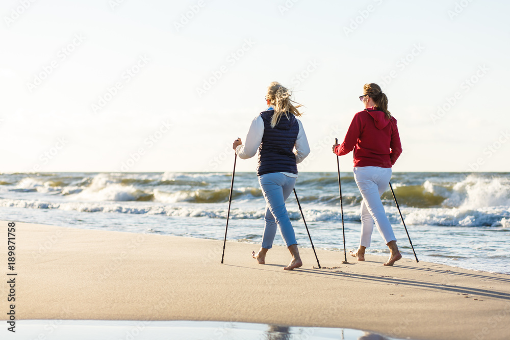 Nordic walking - active people working on beach - obrazy, fototapety, plakaty 