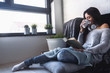 © lordn - Beautiful young woman at home drinking coffee reading a book