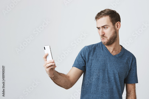 Playful Caucasian Man With Dark Hair Blue Eyes And Beard Holding
