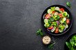 Leinwandbild Motiv Healthy vegetable salad of fresh tomato, cucumber, onion, spinach, lettuce and sesame on plate. Diet menu. Top view.