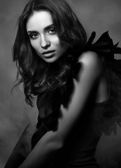 Wall Mural - Black and white fashion portrait. Beautiful, sexy young woman in black. Professional makeup and hairstyle