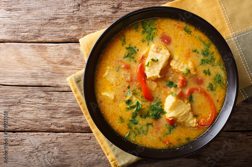 Fotografie, Tablou Brazilian food: Moqueca Baiana of fish and bell peppers in spicy coconut sauce close-up on a plate