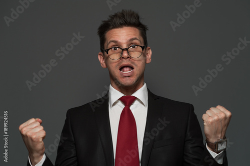 Fotografie, Obraz Disheveled young man the manager in formal suit is pleased with unexpected succe