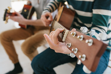 Wall Mural - Learning to play the guitar. Music education and extracurricular lessons. Hobbies and enthusiasm for playing guitar and singing songs.