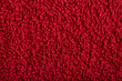 red fabric and texture concept - close up of a towel terrycloth or terry textile background