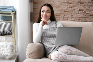 Canvas Print - Young woman using laptop indoors