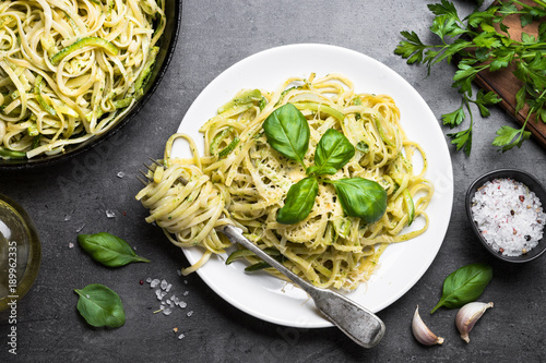 Fotomural Pasta spaghetti with zucchini basil and cheese on black.