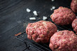 raw hamburger patties with onions and herbs