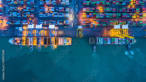 Fotomural Aerial view container cargo ship working at night with industry crane, Container cargo ship business commerce import export logistic, Logistic and transportation of International container cargo ship