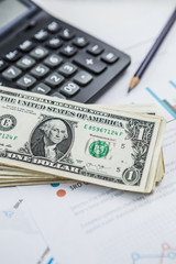 Calculator with american dollars on the wooden table background, finance concept