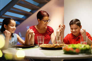 Dinner At Home With Happy Family Praying Before Eating