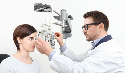 optometrist doing eyesight with woman patient measurement with optical phoropter isolated on white